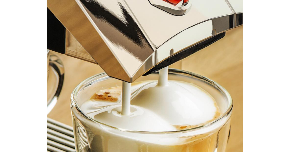 Zbliżenie na przygotowywanie mlecznej pianki do kawy z ekspresu